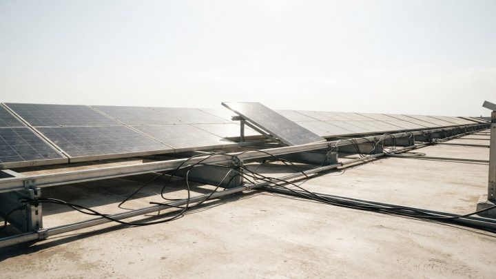 Imagen ilustrativa: arreglo solar de azotea descuidado a plena luz, con cableado suelto colgando y un módulo desalineado.